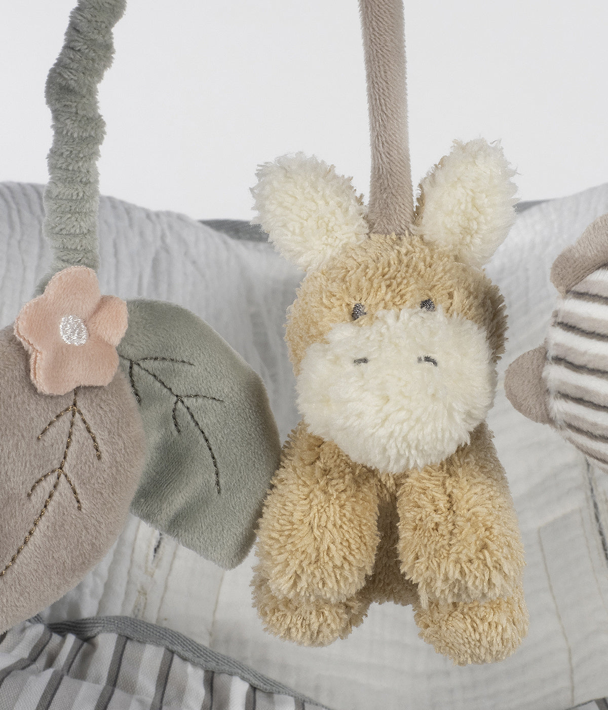 Espiral de atividades para bebé Botton Strips da Walking Mum em tons de verde e bege alia funcionalidade a estimulação sensorial.