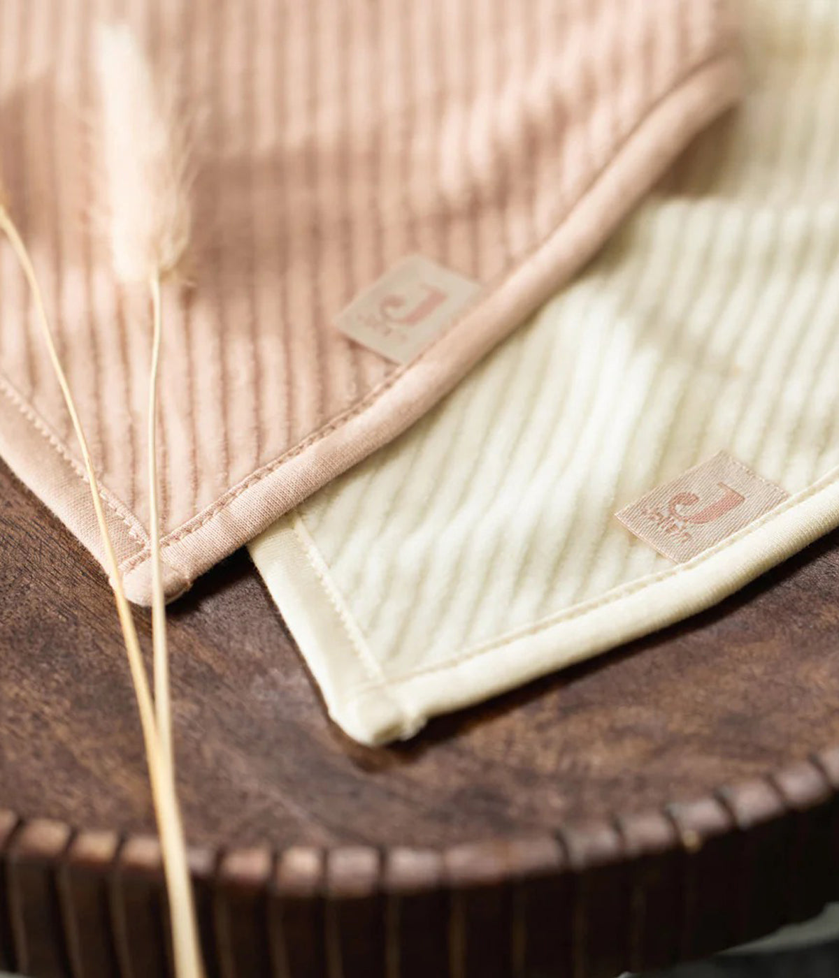 Conjunto de duas babetes em veludo canelado da Jollein para bebé menina e recém-nascida. Suaves babetes, uma pérola e outra rosa, perfeitas para manter a bebé limpa enquanto aprende a beber e comer sozinha.