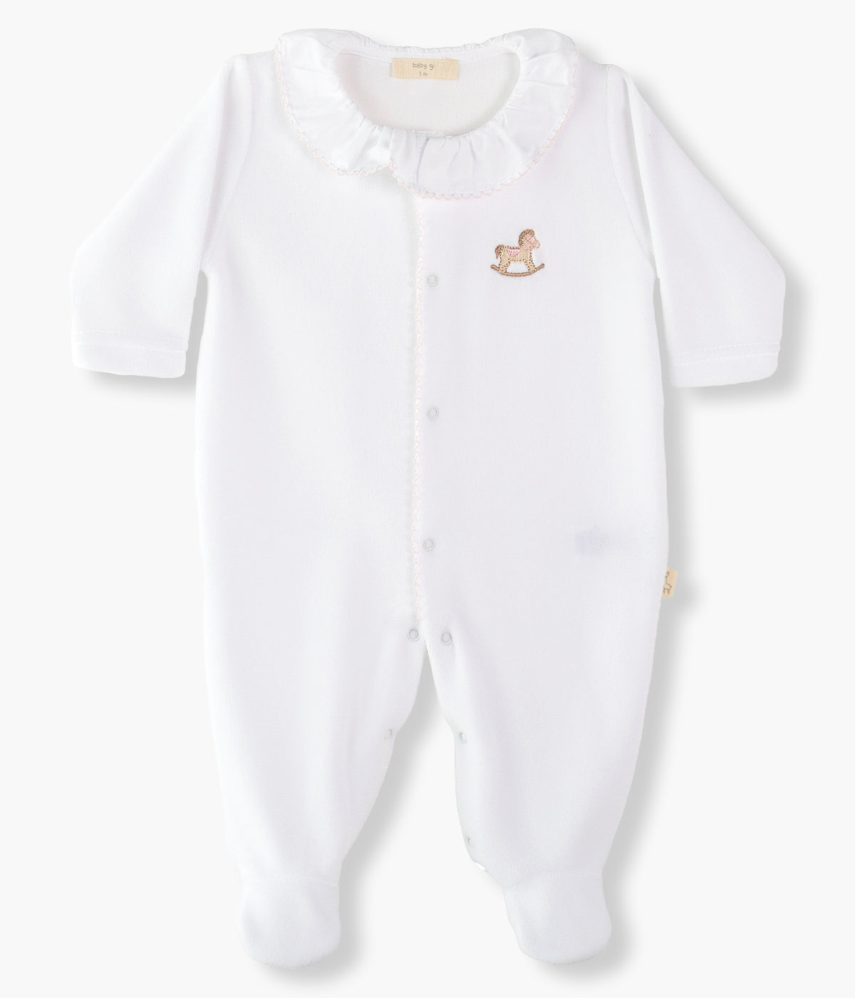 Babygrow em veludo branco da Baby Gi para bebé menina e recém-nascida. Gola folho e contorno na abertura com picueta rosa. Pequeno cavalo de madeira bordado no peito. Abertura com molas de pressão na frente e entrepernas.