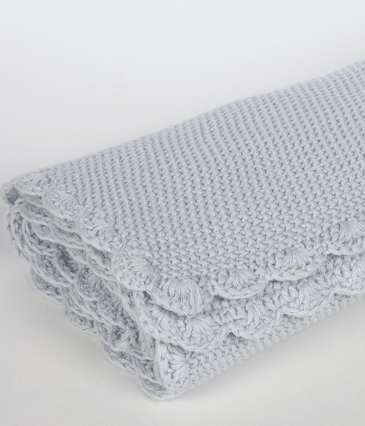 Manta de malha em algodão tricot azul da Pasito a Pasito para bebé menino e recém-nascido com rebordo ondulado.