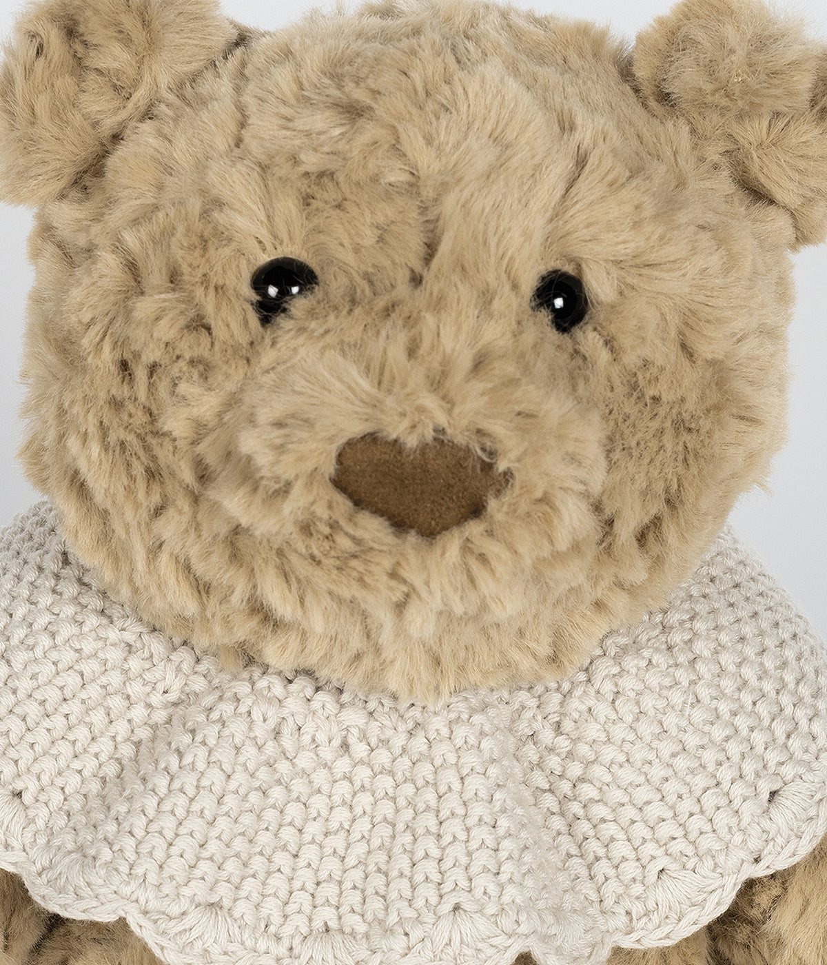 Urso de peluche bege da Pasito a Pasito para bebé. Delicado urso com textura aveludada ideal para o contacto com a pele sensível do bebé. O detalhe da gola em tricot, numa tonalidade delicada de bege, confere um toque clássico e amoroso ao seu visual, tornando-o ainda mais especial.