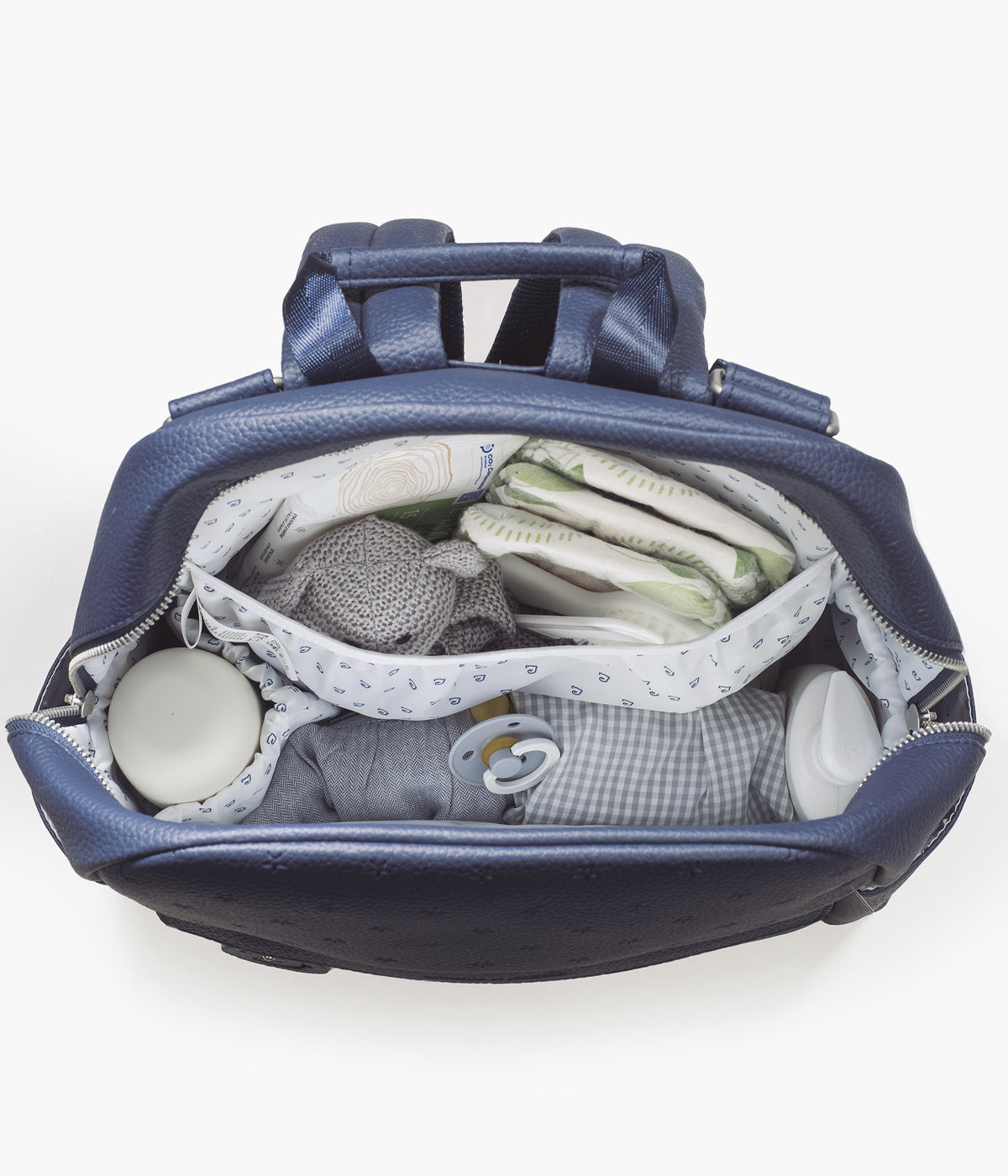 Mochila de Maternidade Pasito a Pasito New London Blue em polipele de cor azul-marinho vista de cima cheia com coisas de bebé.
