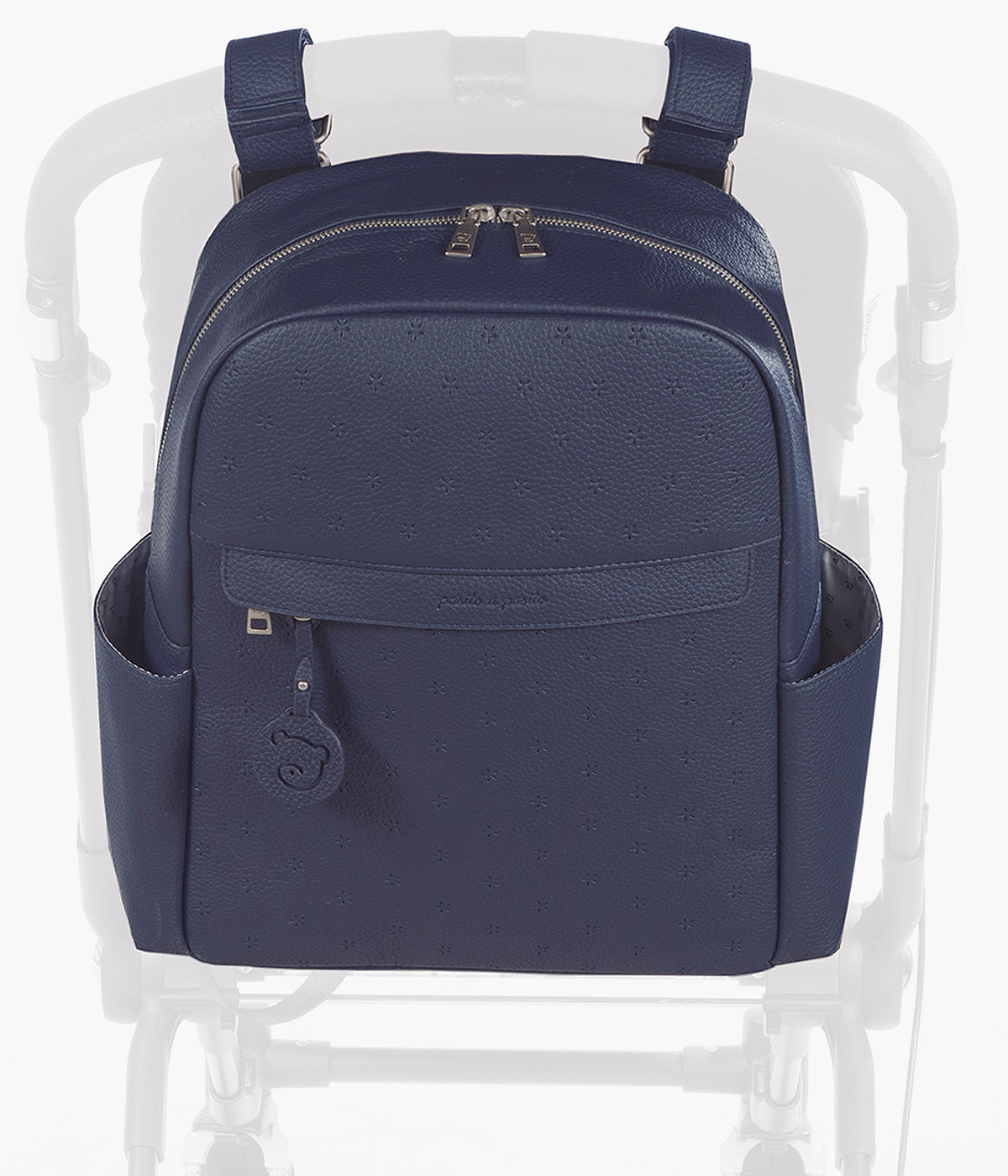 Mochila de Maternidade Pasito a Pasito New London Blue em polipele de cor azul-marinho pendurada no carrinho.