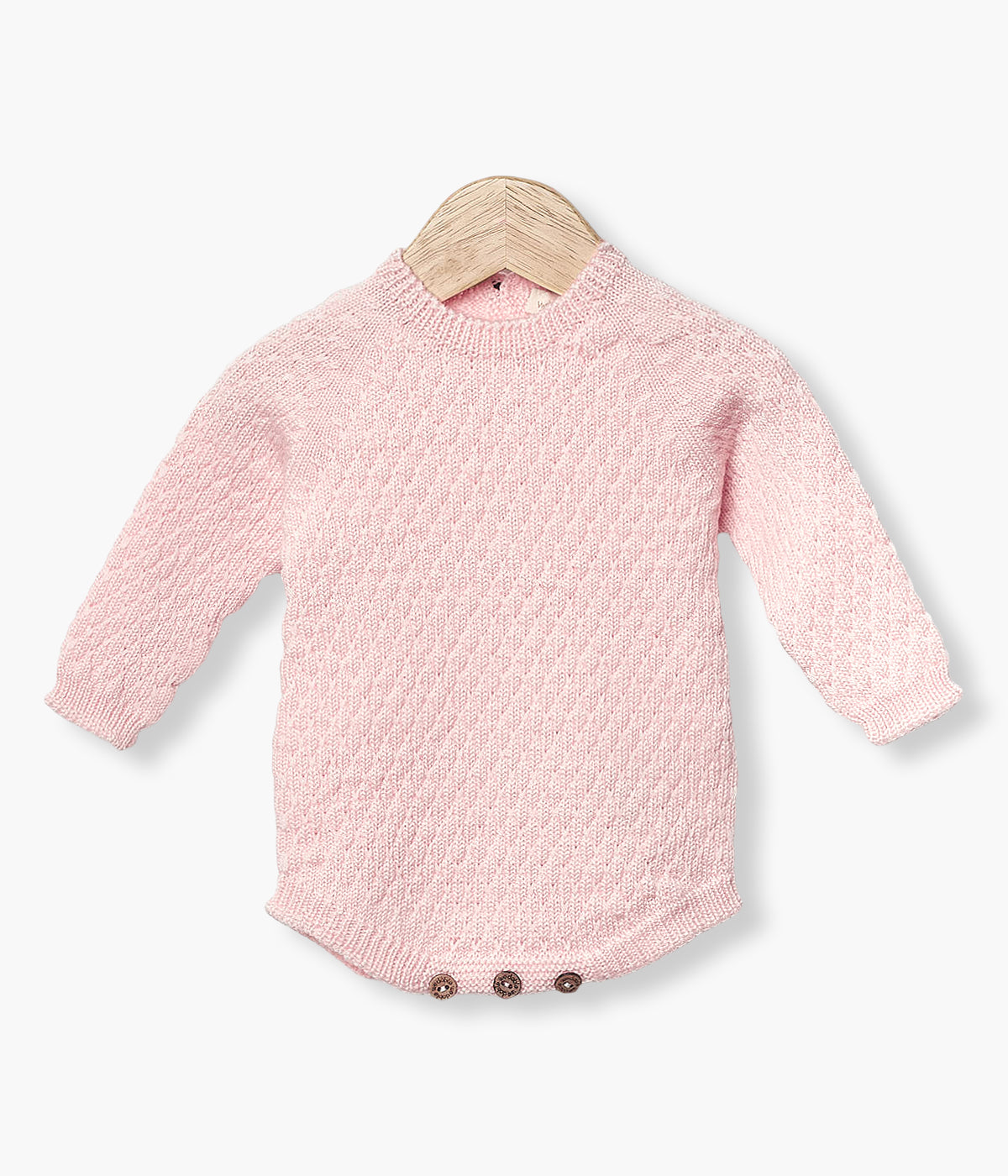 Fofo tricotado em lã merino cor-de-rosa da Wedoble para bebé menina e recém-nascida. Suave fofo com detalhes entrelaçados na malha de abertura nas costas e entrepernas.