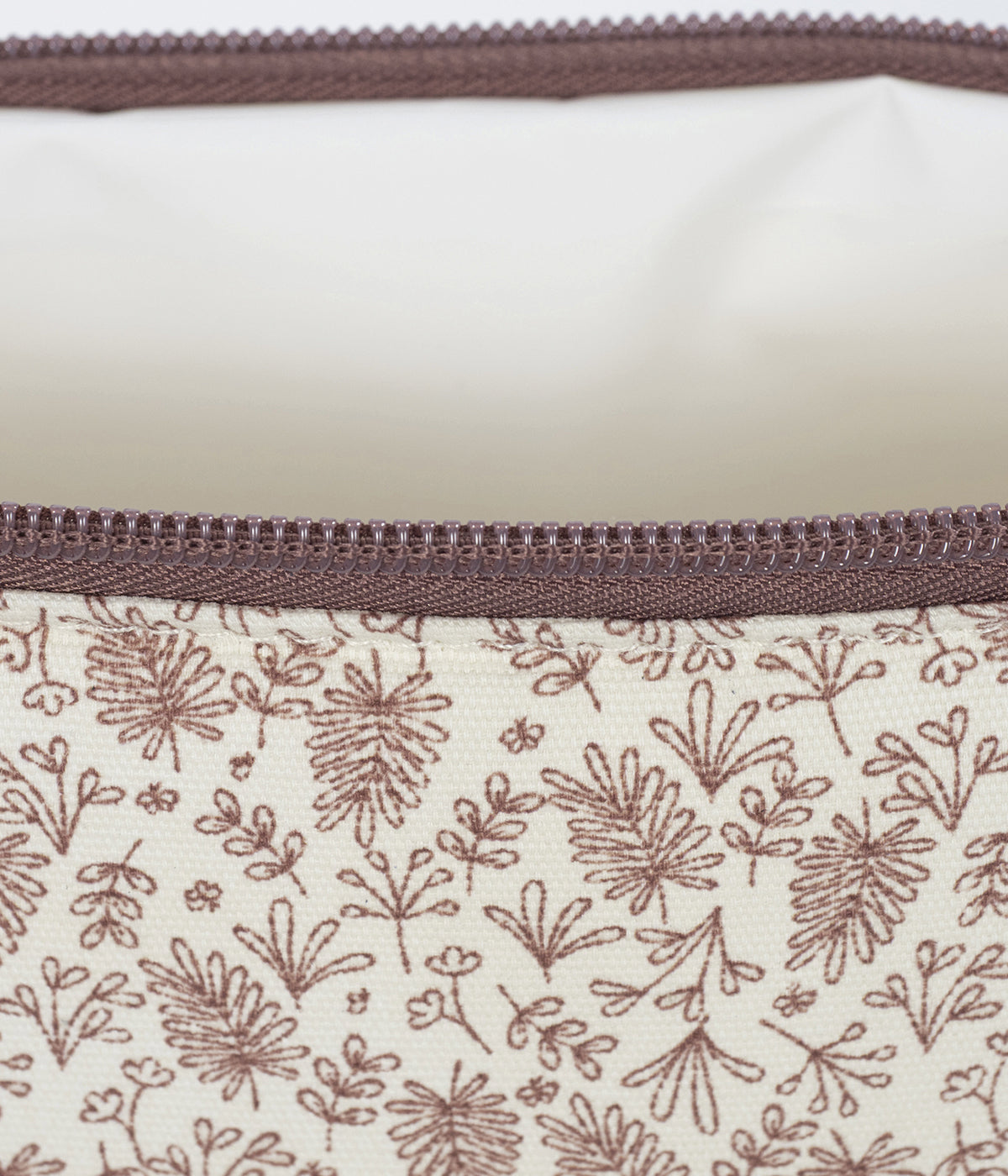 Necessaire Gala Cerise da Walking Mum, pequena bolsa com exterior em algodão impermeável pensada para facilitar o transporte dos artigos de higiene da bebé. Com um encantador padrão ramos em tons de cereja em fundo pérola, é perfeito para os pais que procuram um acessório prático e sofisticado.