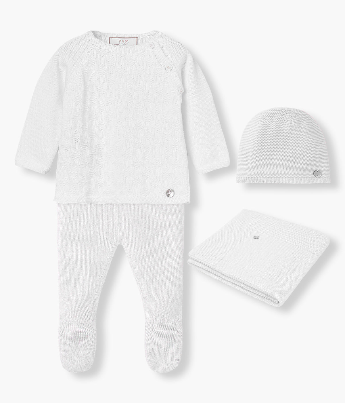 Vista de frente do conjunto de 4 peças em malha de algodão branco da Paz Rodríguez para bebé e recém-nascido(a). Camisola de abertura no ombro com detalhes na malha. Calças lisas com pés. Gorro liso com medalha madrepérola. Manta simples de formato retangular.