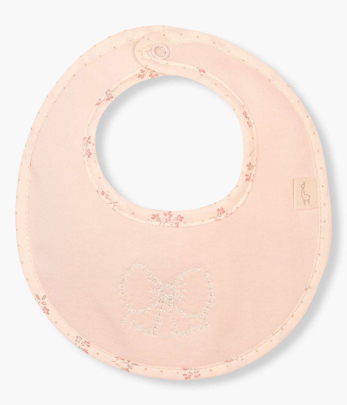 Vista frontal da babete rosa da Baby Gi para bebé menina e recém-nascida, 100% algodão. Elegante babete de formato redondo com laço bordado e contornos com padrão pequenas flores.
