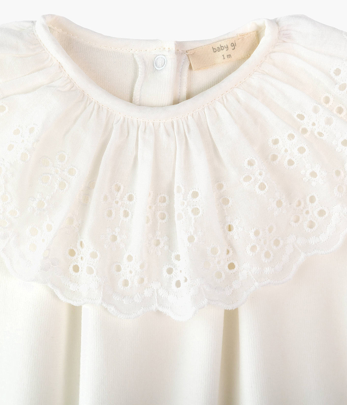 Fotografia de detalhe da gola do babygrow em veludo pérola da Baby Gi para bebé e recém-nascido(a).