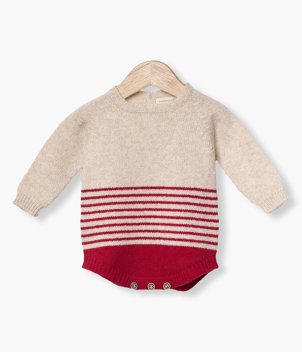 Fofo tricotado em lã merino da Wedoble para bebé e recém-nascido(a). Parte superior em bege e parte inferior com riscas em vermelho. Abertura nas costas e entrepernas.