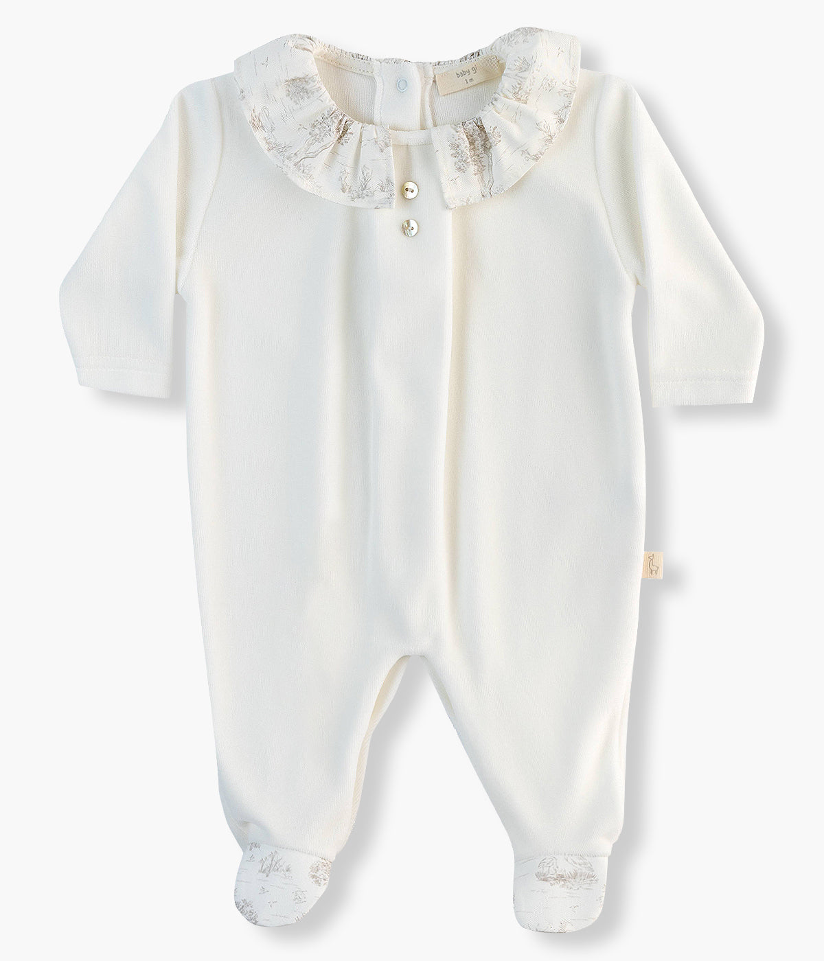 Babygrow em veludo pérola da Baby Gi para bebé e recém-nascido(a). Gola folho cortada com padrão toile de jouy e dois botões decorativos madrepérola no peito. Abertura com molas de pressão nas costas e entrepernas.