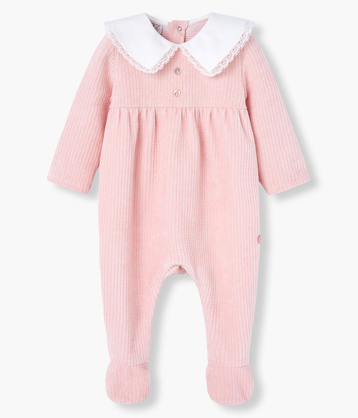 Babygrow em veludo canelado cor-de-rosa da Paz Rodríguez para bebé menina e recém-nascida. Delicado babygrow com gola bico cortada com renda detalha em pérola, dois botões madrepérola decorativos e medalha com logo da marca.