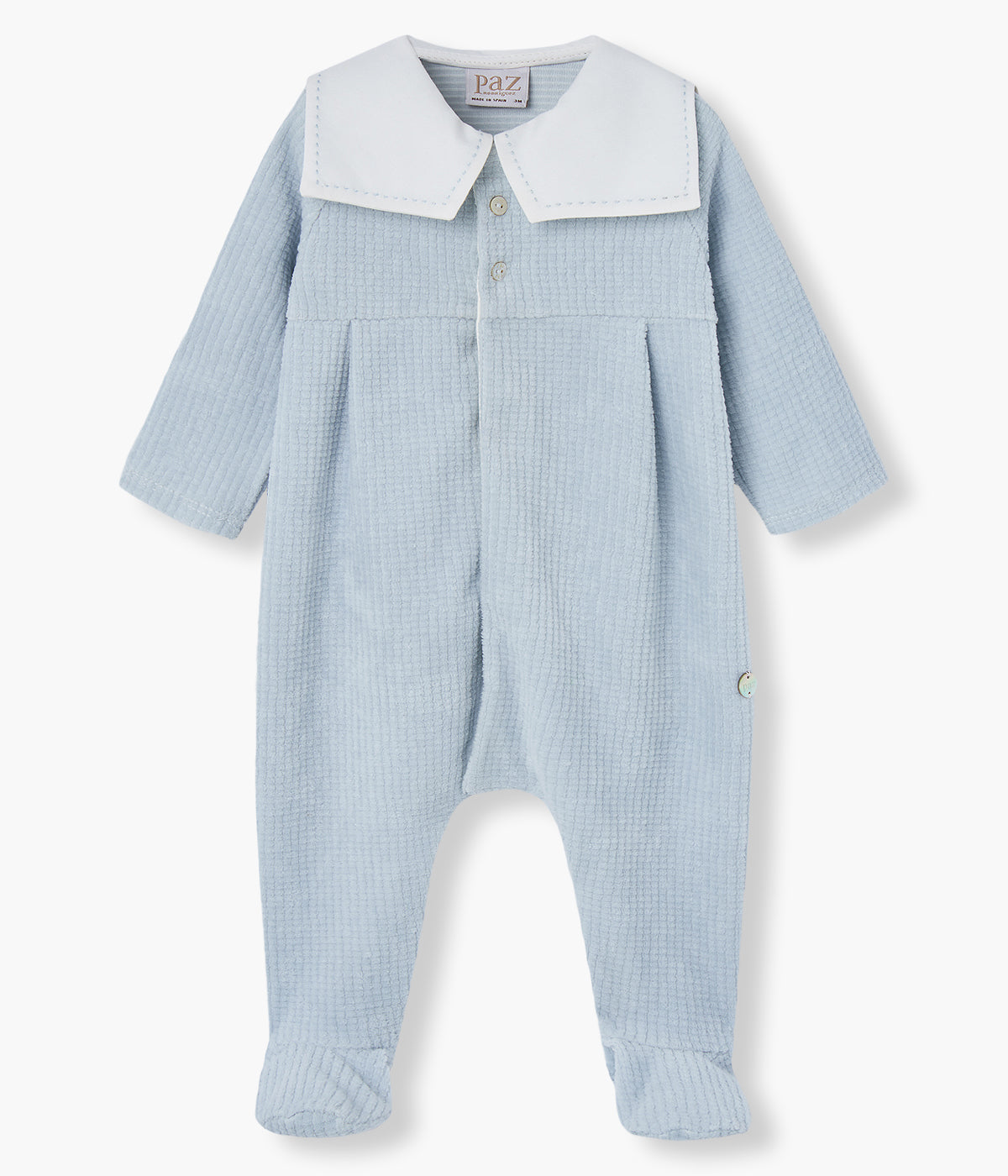 Babygrow em veludo canelado azul da Paz Rodríguez para bebé menino e recém-nascido. Delicado babygrow com gola de estilo marinheiro, dois botões madrepérola decorativos e medalha com logo da marca.
