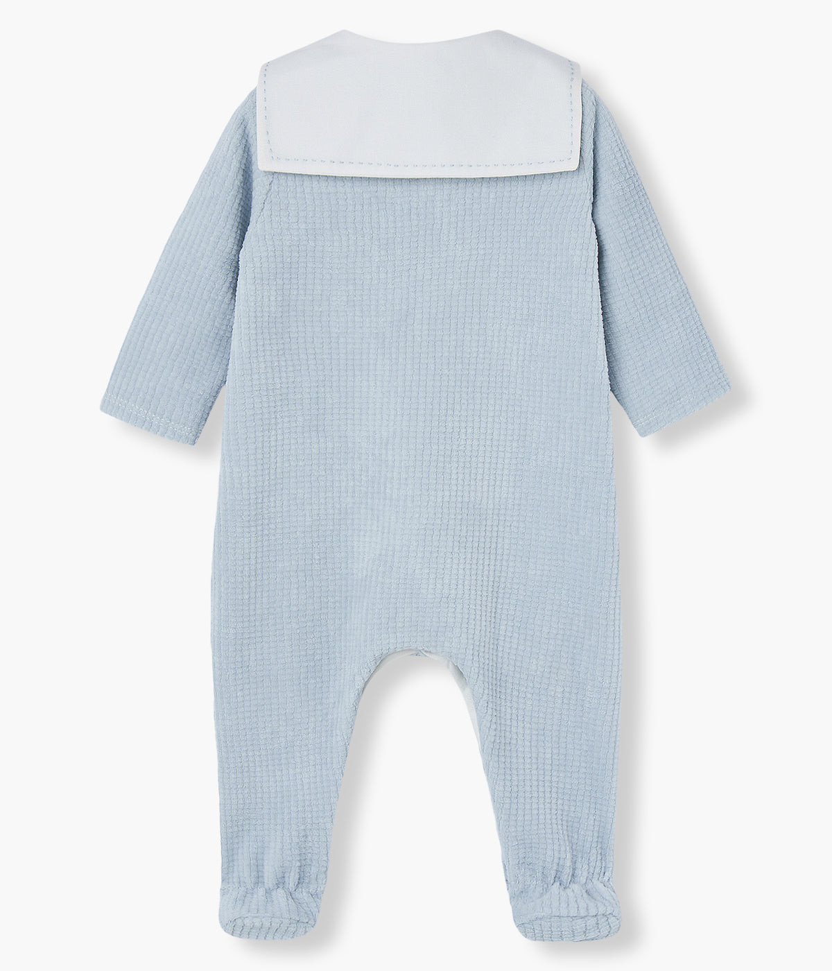 Babygrow em veludo canelado azul da Paz Rodríguez para bebé menino e recém-nascido. Delicado babygrow com gola de estilo marinheiro, dois botões madrepérola decorativos e medalha com logo da marca.