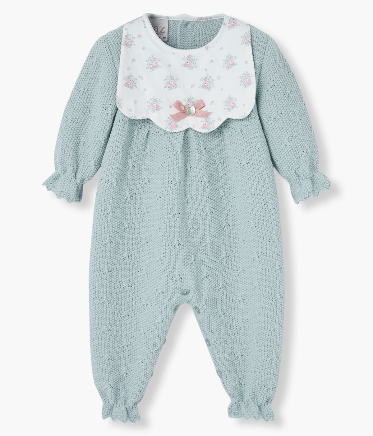 Babygrow em malha verde-água da Paz Rodríguez para bebé menina e recém-nascida. Elegante babygrow com peitilho de padrão floral em fundo pérola, detalhes na malha e pequeno laço com medalha da marca.