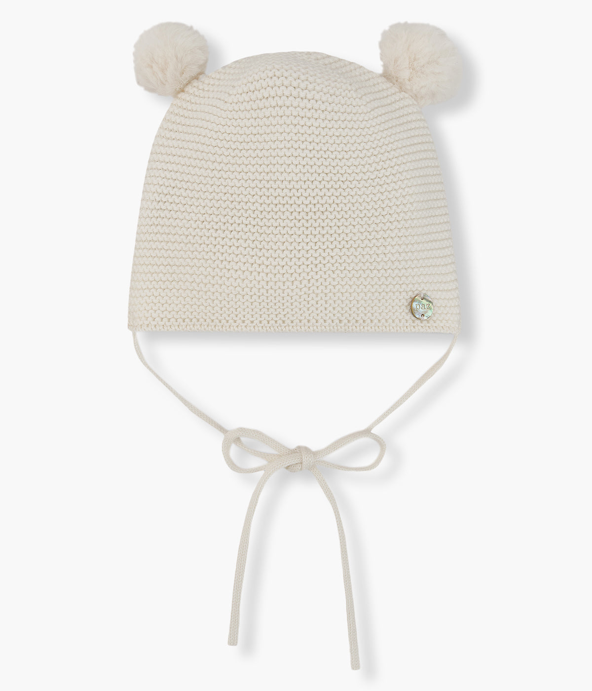 Gorro em malha pérola da Paz Rodríguez para bebé e recém-nascido(a). Suave gorro em malha com dois pompons e tiras para atar no queixo.