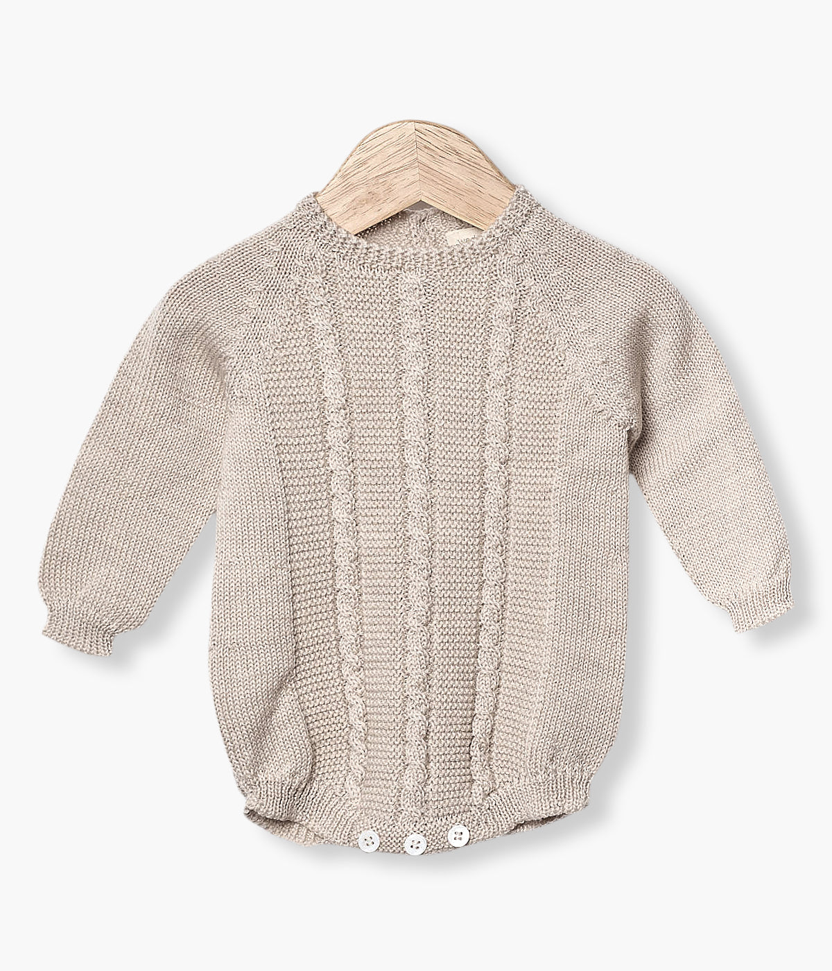 Fofo tricotado em lã merino bege da Wedoble para bebé e recém-nascido(a). Suave fofo com detalhes entrelaçados na malha de abertura nas costas e entrepernas.