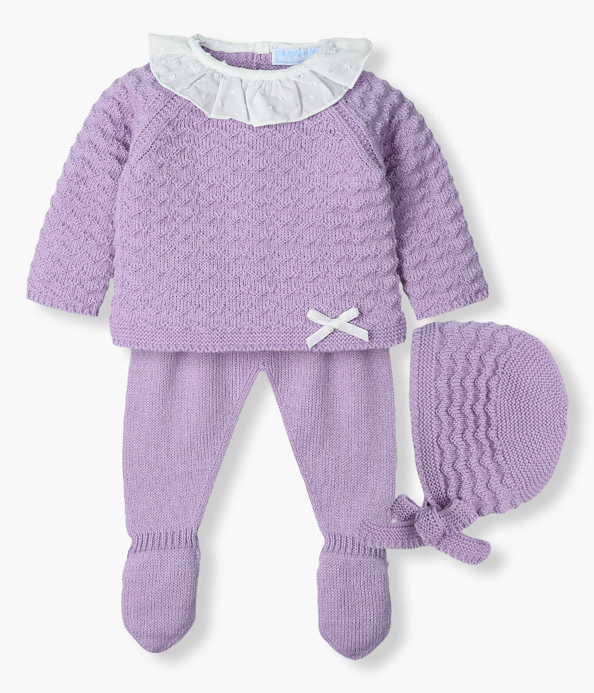 Conjunto de 3 peças em malha lilás da Mac Ilusión composto por camisola, calças e touca para bebé menina e recém-nascida. Camisola com gola folho em tecido plumeti branco, laço no canto inferior e detalhes na malha. Touca com detalhes a combinar. Calças com pés.