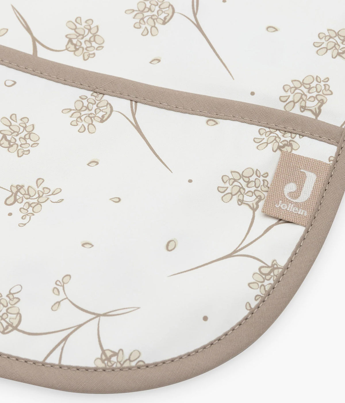 Babete impermeável pérola com mangas com padrão dentes-de-leão em tons de bege para bebé. Babete com mangas e bolso perfeita para o bebé utilizar nas refeições ou em outras atividades. Graças ao fecho em velcro, esta babete adapta-se tanto a bebés como a crianças pequenas.