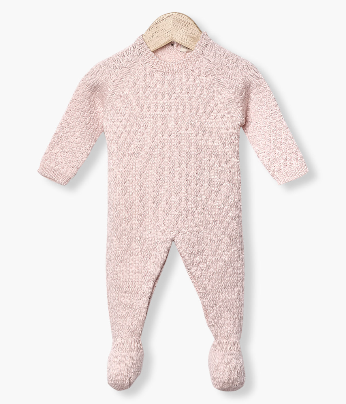 Babygrow tricotado em lã merino rosa da Wedoble para bebé menina e recém-nascida. Suave babygrow com detalhes entrelaçados na malha de abertura nas costas e entrepernas.