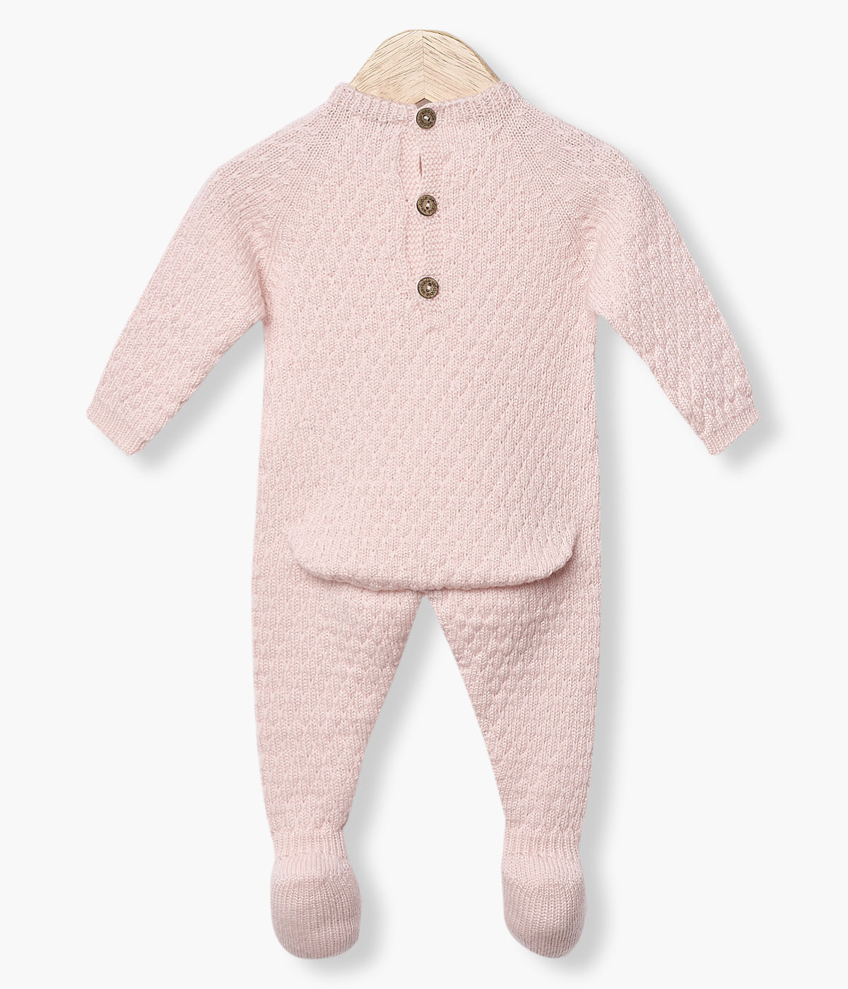 Babygrow tricotado em lã merino rosa da Wedoble para bebé menina e recém-nascida. Suave babygrow com detalhes entrelaçados na malha de abertura nas costas e entrepernas.