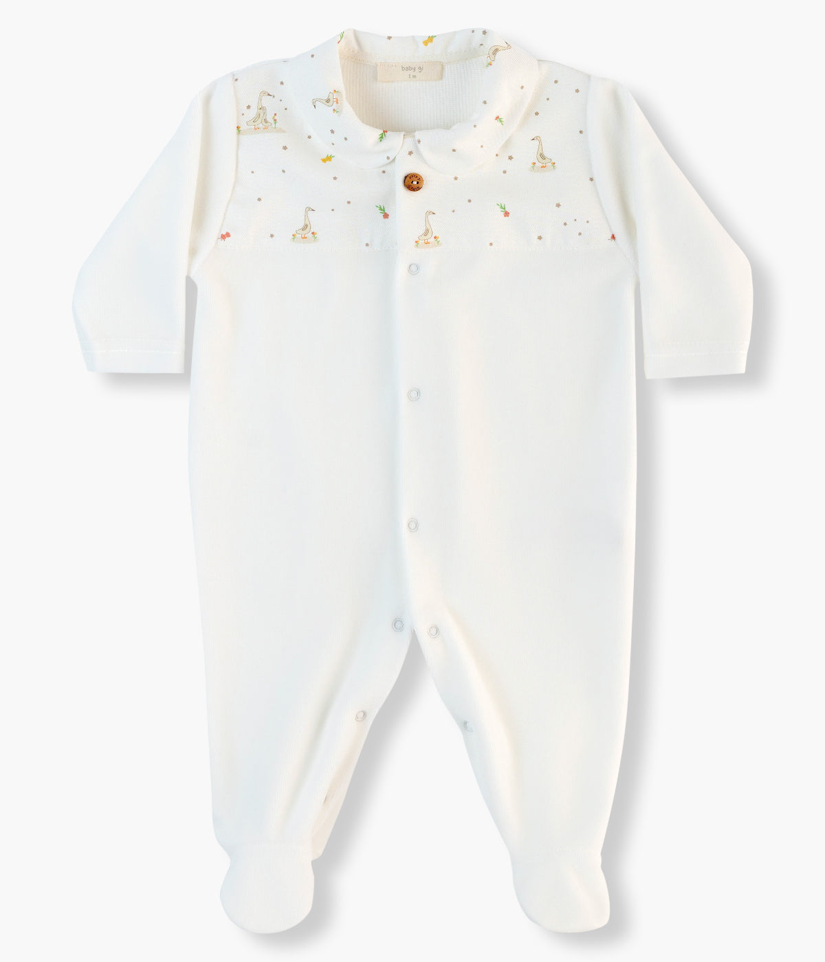 Babygrow em veludo pérola da Baby Gi para bebé e recém-nascido(a). Gola redonda cortada e aplicação em tecido no peito com padrão gansos com um botão decorativo. Abertura na frente e entrepernas.