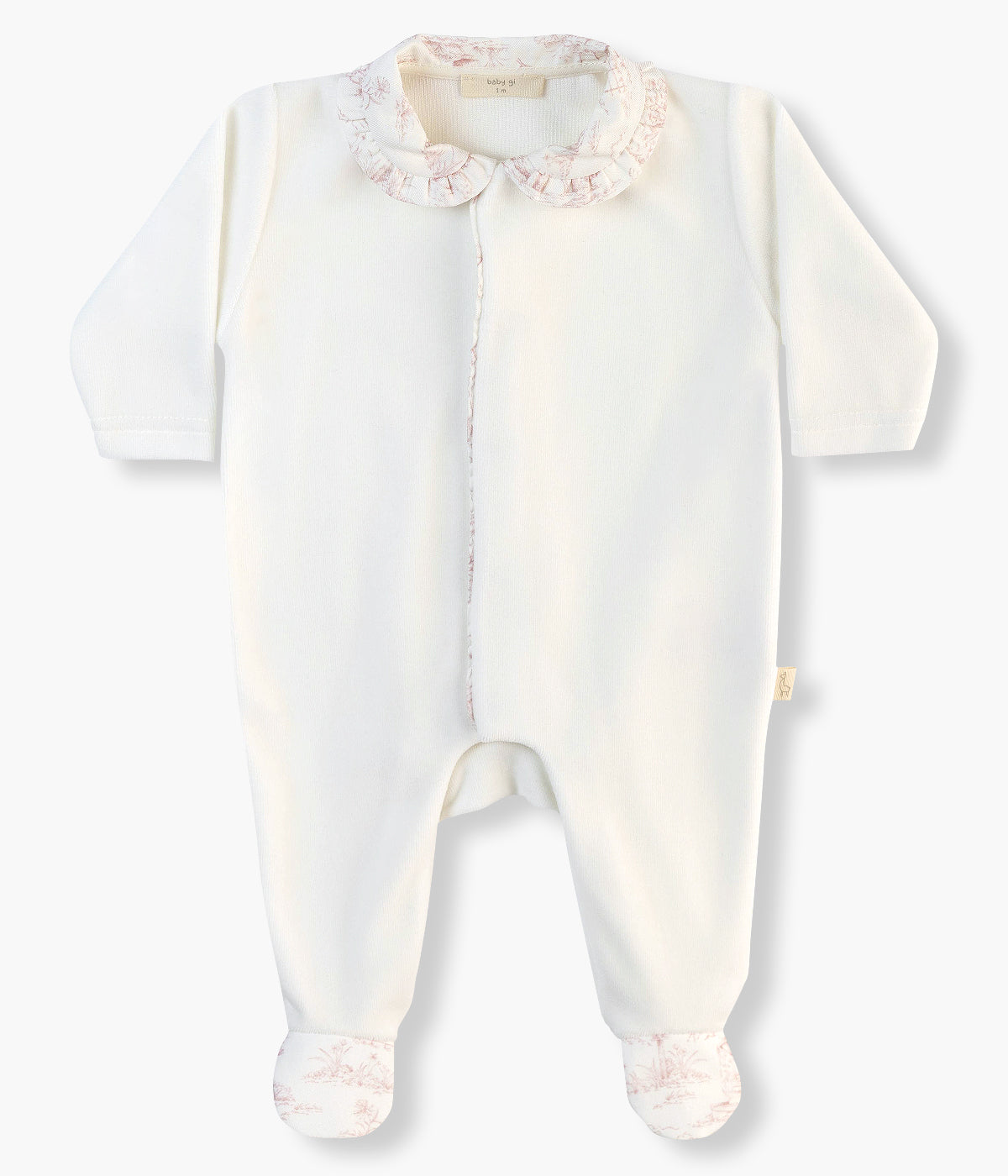 Babygrow em veludo pérola da Baby Gi para bebé menina e recém-nascida. Gola redonda cortada, faixa na abertura e pés com aplicação em tecido de padrão toile de jouy cor-de-rosa. Abertura na frente e entrepernas.