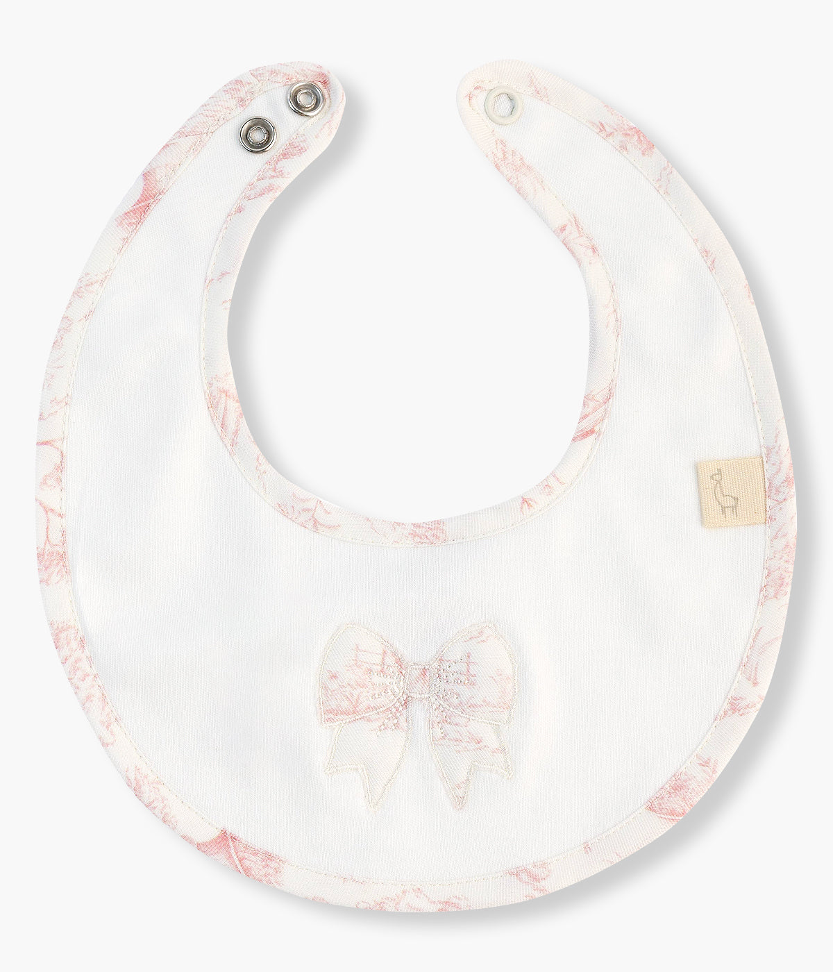 Babete impermeável pérola da Baby Gi para bebé menina e recém-nascida, 100% algodão. Elegante babete redonda com laço bordado e rebordo a toda a volta com padrão toile de jouy em tons de rosa.
