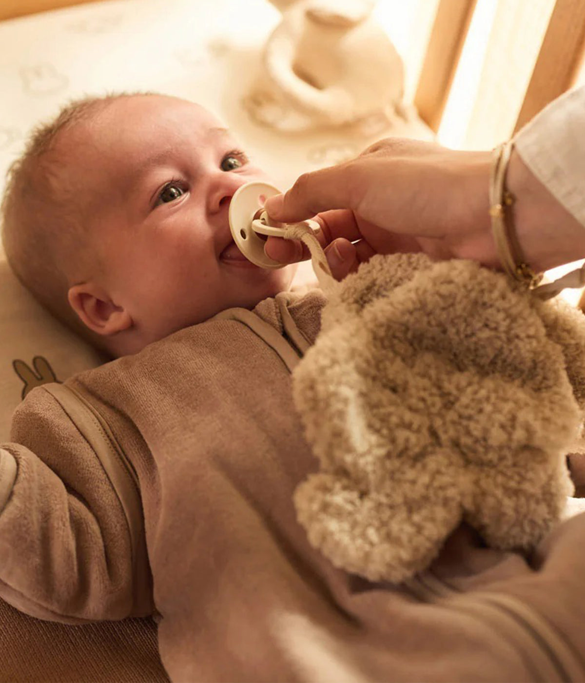 Doudou Prende Chupetas Elephant Tales da Jollein. Em tons de bege, super macio e adorável, este doudou com forma de elefante e laço para prender a chupeta é um companheiro prático e irresistível para o bebé.