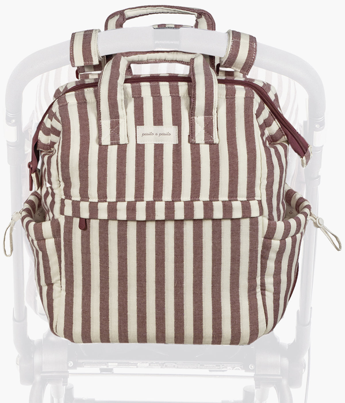 Mochila de maternidade Cherry Strips da Pasito a Pasito pendurada num carrinho de bebé.