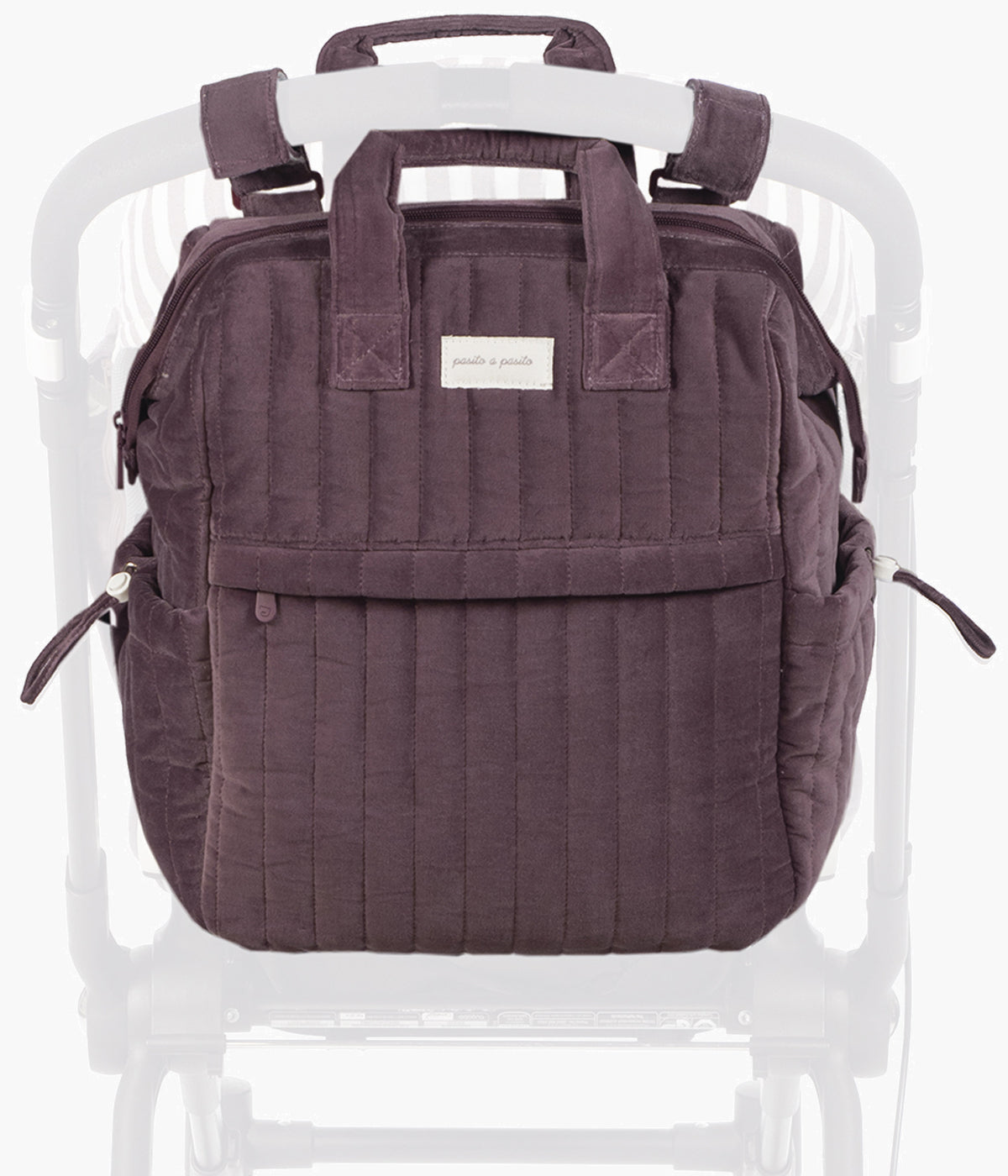 Mochila de maternidade Cherry Velvet da Pasito a Pasito pendurada no carrinho.