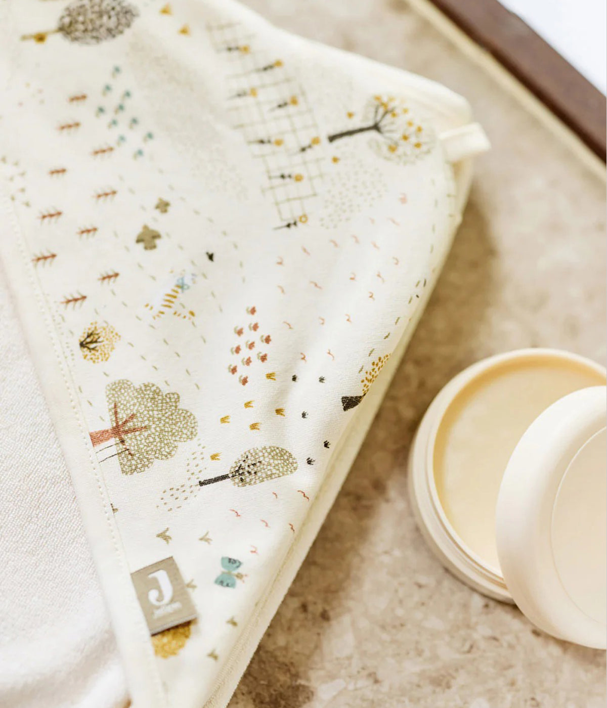 Toalha de banho em algodão para bebé e recém-nascido(a) coleção Tiny Park da Jollein. Tecido de algodão turco muito absorvente de cor pérola e exterior com padrão animais e árvores. Carapuço no canto.