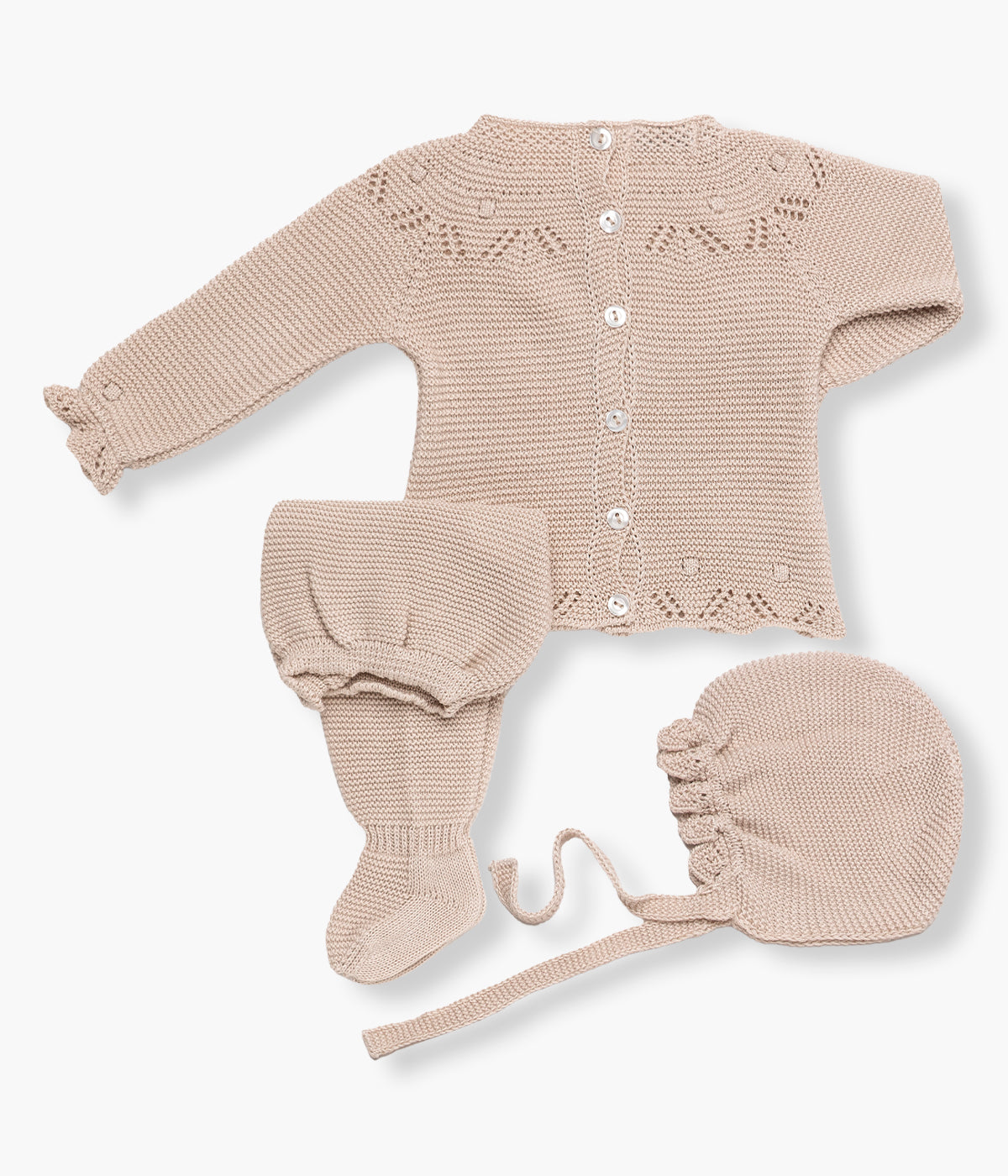 Vista de costas do conjunto em malha bege da Juliana para bebé menina e recém‑nascida, composto por camisola, calças e touca. Camisola com detalhes perfurados nos contornos e laço em renda pérola. Touca com pequeno rebordo ondulado a toda a volta. Calças lisas com pés.