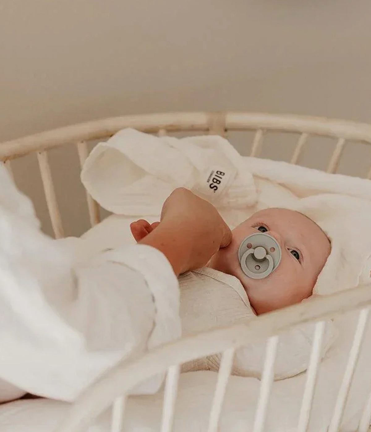 Bebé com swaddle musselina da Bibs para bebé e recém-nascido(a). Feita em musselina de algodão orgânico certificado na cor marfim (ivory).