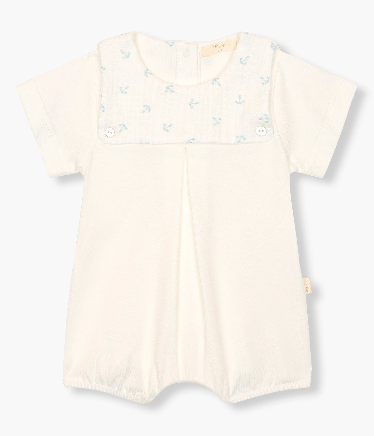 Vista de frente do fofo em algodão pérola da Baby Gi para bebé e recém-nascido(a). Peitilho com detalhe em tecido musselina com padrão âncoras azuis e dois botões madrepérola decorativos.