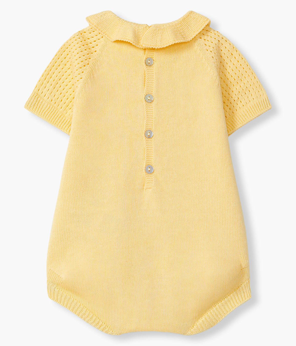 Vista de costas do fofo em malha de algodão orgânico amarelo da Wedoble para bebé e recém-nascido(a). Delicado fofo com gola folho, detalhes perfurados na malha e botão madrepérola decorativo. Abertura nas costas e entrepernas.
