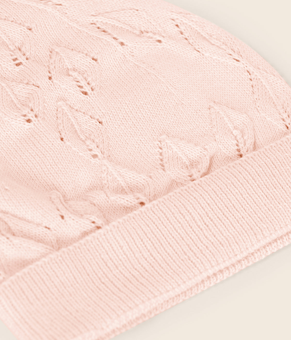 Gorro em malha de algodão orgânico rosa da Wedoble para bebé menina e recém-nascida. Delicado gorro em malha suave com dobra, detalhes perfurados e pormenor no topo.