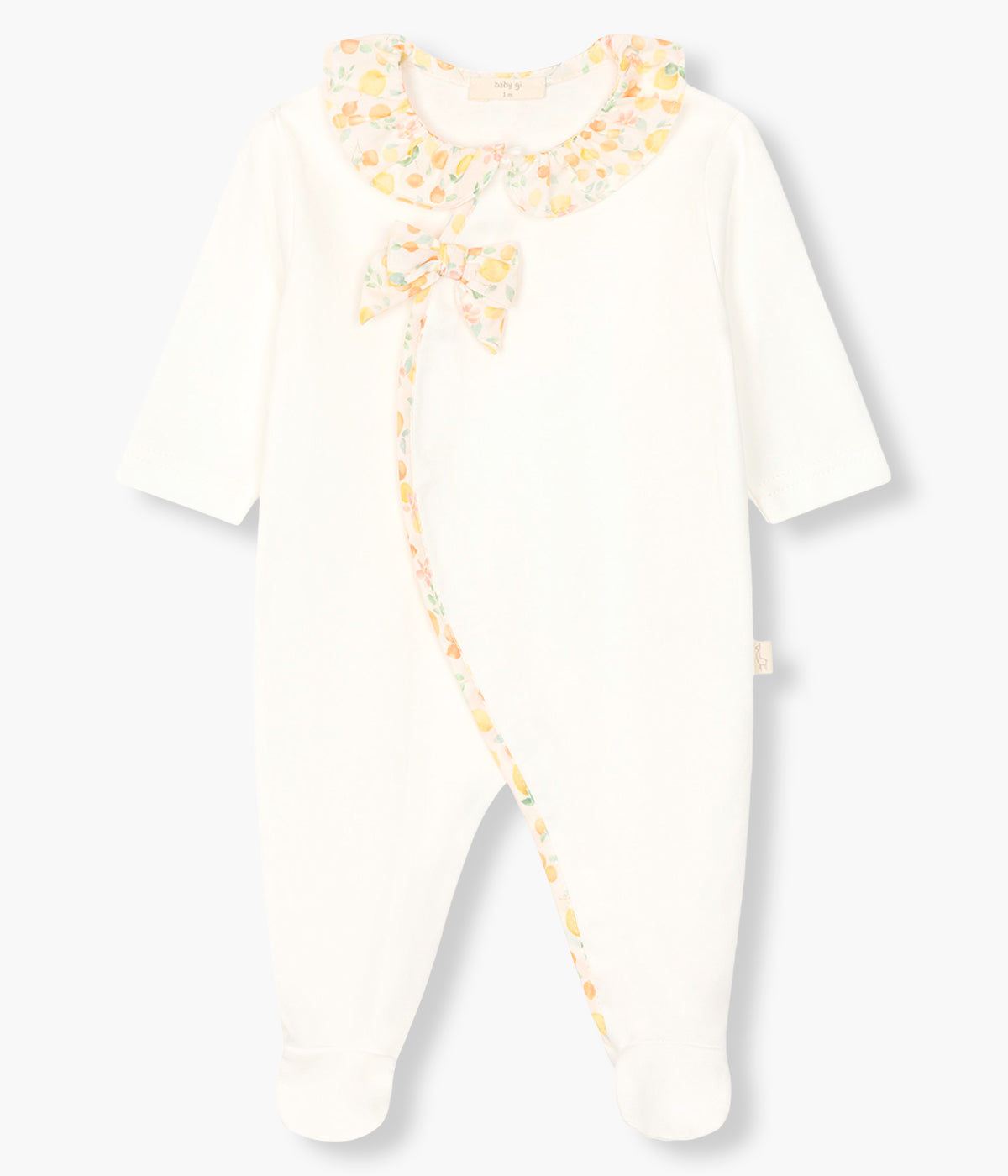 Vista de frente do babygrow em algodão pérola da Baby Gi para bebé menina e recém-nascida. Gola redonda cortada, laço e abertura com padrão frutas coloridas. Abertura com molas de pressão na frente e entrepernas.