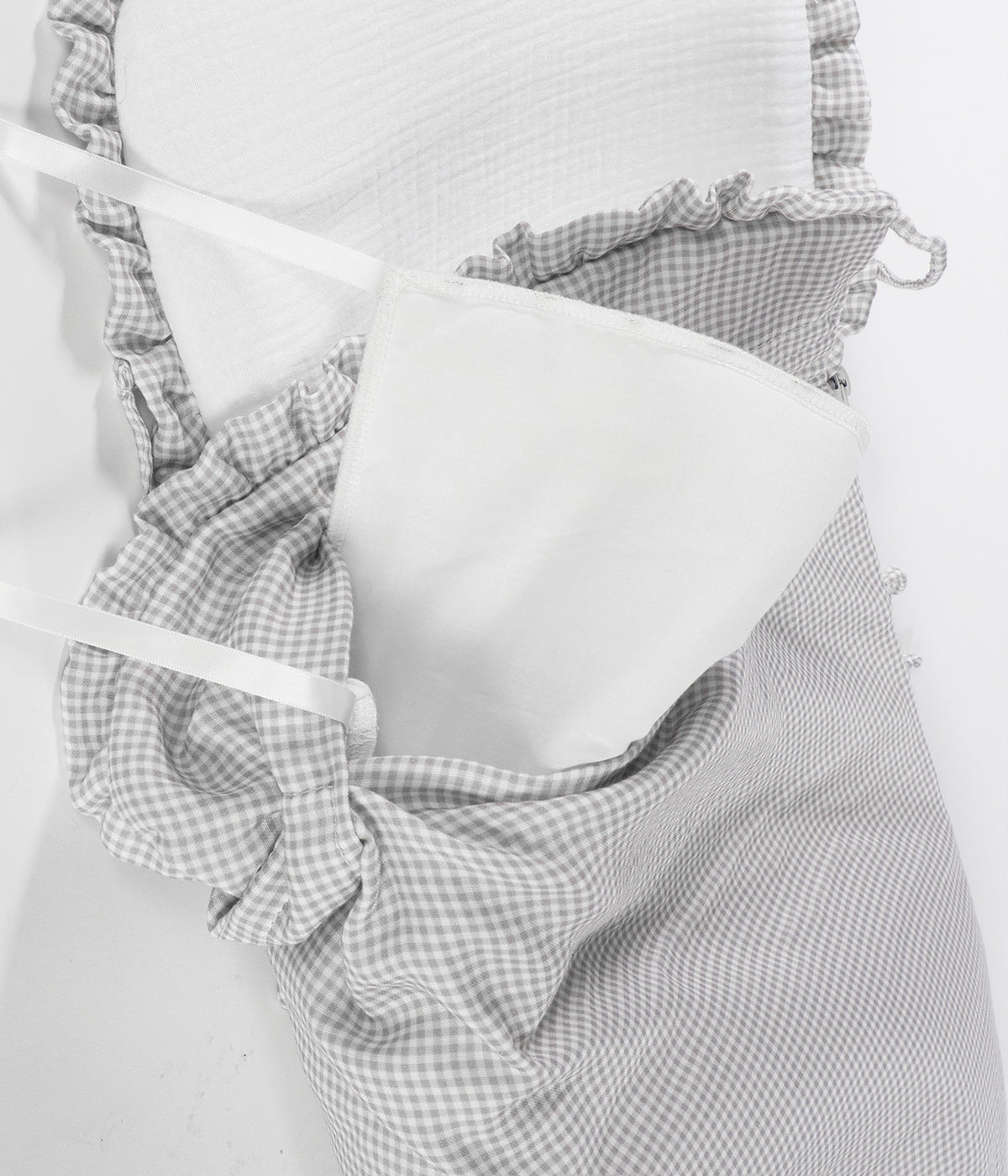 Vista do enchimento do saco de dormir Little Bloom Vichy da Pasito a Pasito. Delicado saco de dormir que envolve o bebé em conforto e suavidade desde os primeiros passeios. Fabricado em 100% algodão, combina muselina com padrão vichy e um interior liso com enchimento removível e colchão interior com tecido 3D para maior ventilação.