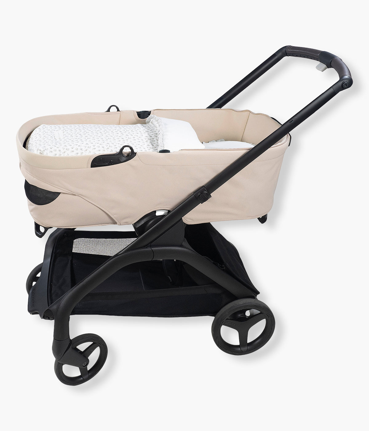 Vista no carrinho do saco de dormir Little Bloom Flowers da Pasito a Pasito. Delicado saco de dormir para alcofa que envolve a bebé em conforto e suavidade desde os primeiros passeios. Criado com tecido 100% algodão, combina muselina com padrão floral cinza, um interior liso com enchimento removível e colchão interior com tecido 3D para maior ventilação.