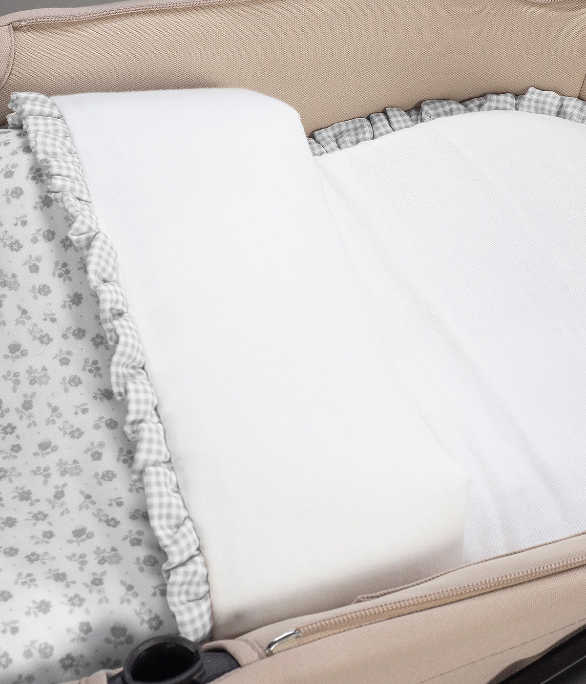 Vista na alcofa do saco de dormir Little Bloom Flowers da Pasito a Pasito. Delicado saco de dormir para alcofa que envolve a bebé em conforto e suavidade desde os primeiros passeios. Criado com tecido 100% algodão, combina muselina com padrão floral cinza, um interior liso com enchimento removível e colchão interior com tecido 3D para maior ventilação.