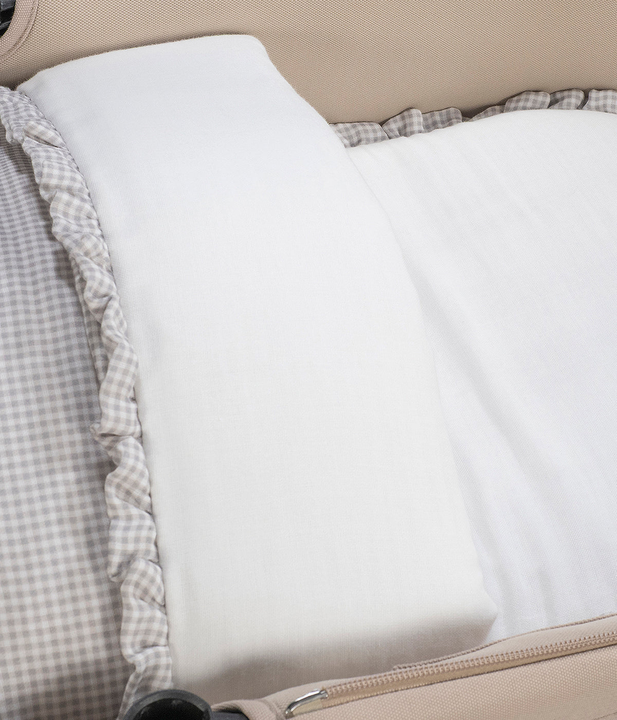 Vista na alcofa do saco de dormir Little Bloom Vichy da Pasito a Pasito. Delicado saco de dormir que envolve o bebé em conforto e suavidade desde os primeiros passeios. Fabricado em 100% algodão, combina muselina com padrão vichy e um interior liso com enchimento removível e colchão interior com tecido 3D para maior ventilação.