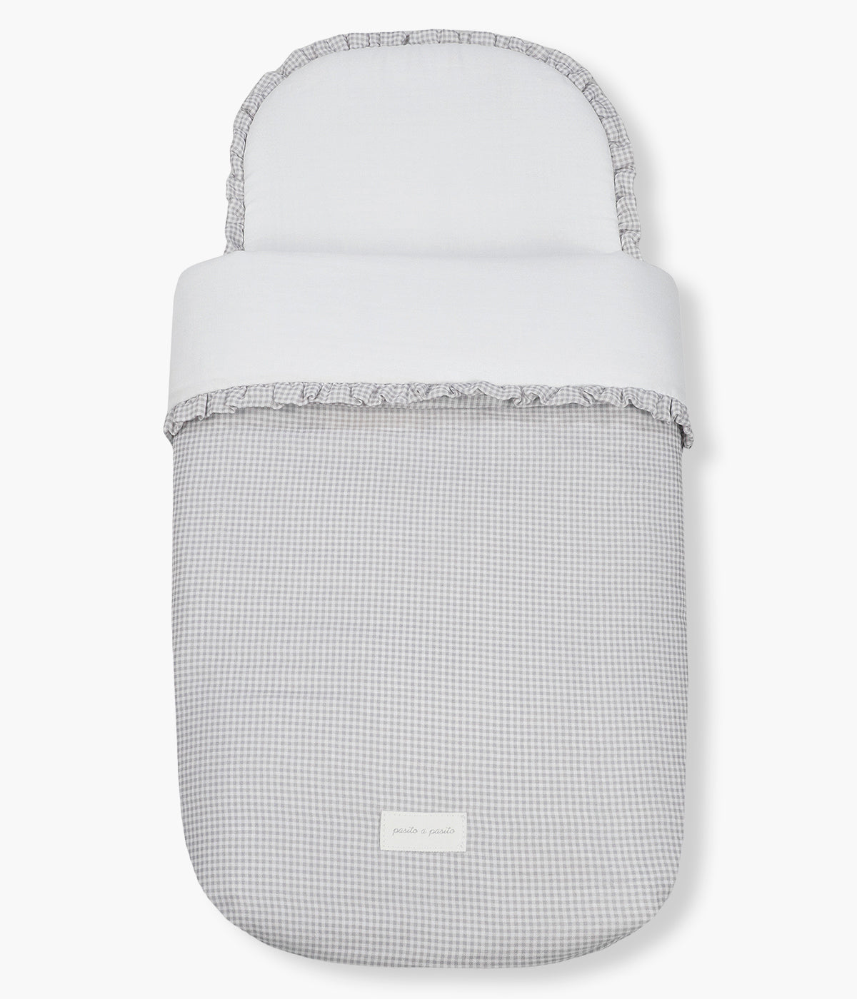 Vista de frente do saco de dormir Little Bloom Vichy da Pasito a Pasito. Delicado saco de dormir que envolve o bebé em conforto e suavidade desde os primeiros passeios. Fabricado em 100% algodão, combina muselina com padrão vichy e um interior liso com enchimento removível e colchão interior com tecido 3D para maior ventilação.