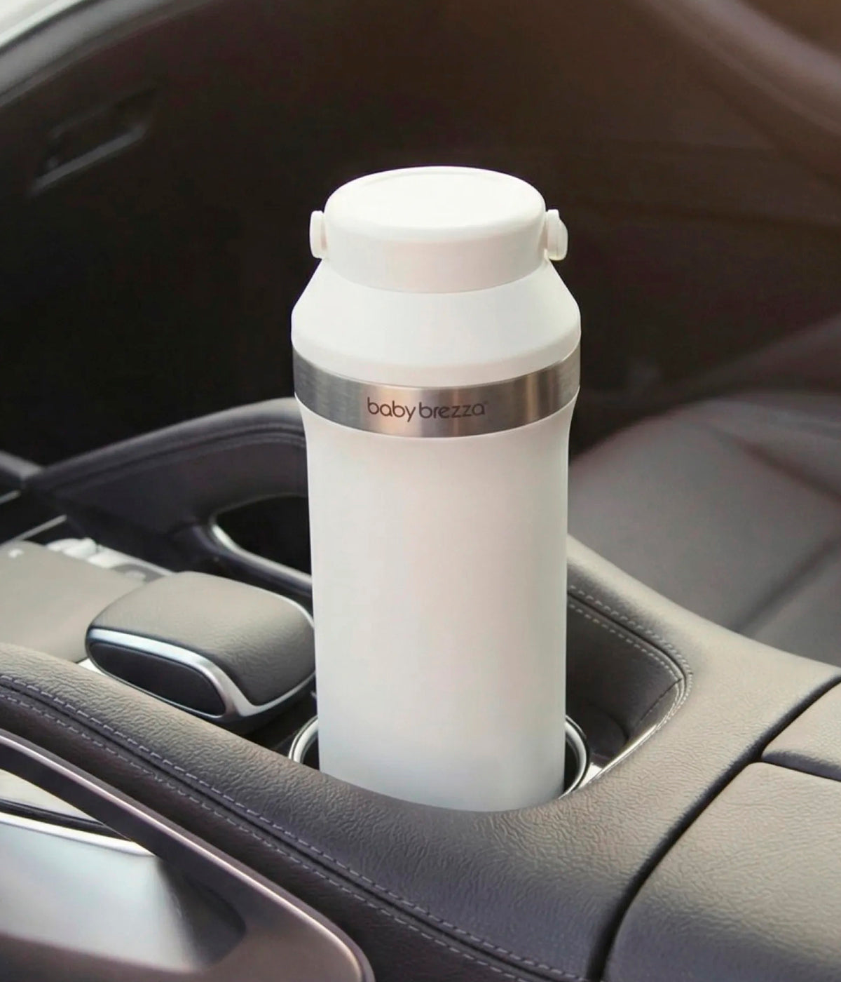 Vista no carro armazenado do refrigerador portátil de leite Materno Baby Brezza All-day Breastmilk Portable Cooler. Prática garrafa térmica com capacidade de 600ml que mantém o leite materno frio até 24 horas, garantindo conservação segura durante todo o dia. Prático, compacto e ideal para mães que extraem leite em casa, no trabalho ou em viagem.