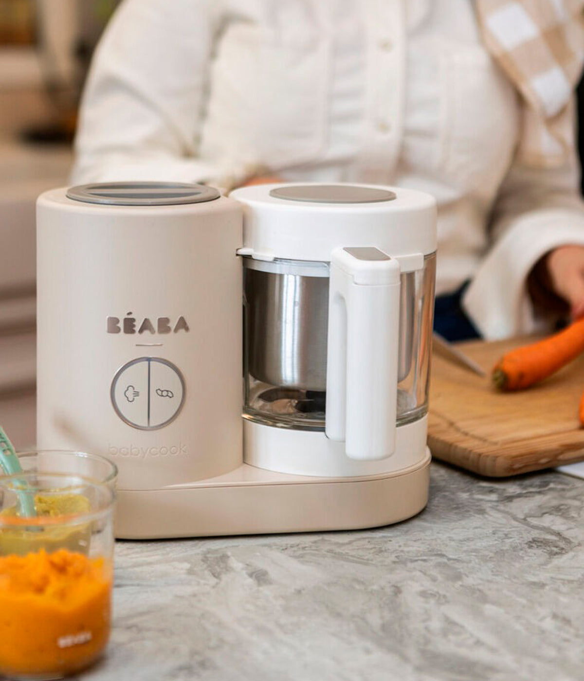 Vista frontal do robô de Cozinha Babycook Néo da Béaba na cor Clay Earth (bege). Inteligente robô de cozinha premium para bebé 6 em 1 que cozinha a vapor, tritura, descongela, aquece refeições, aquece biberões e esteriliza acessórios.