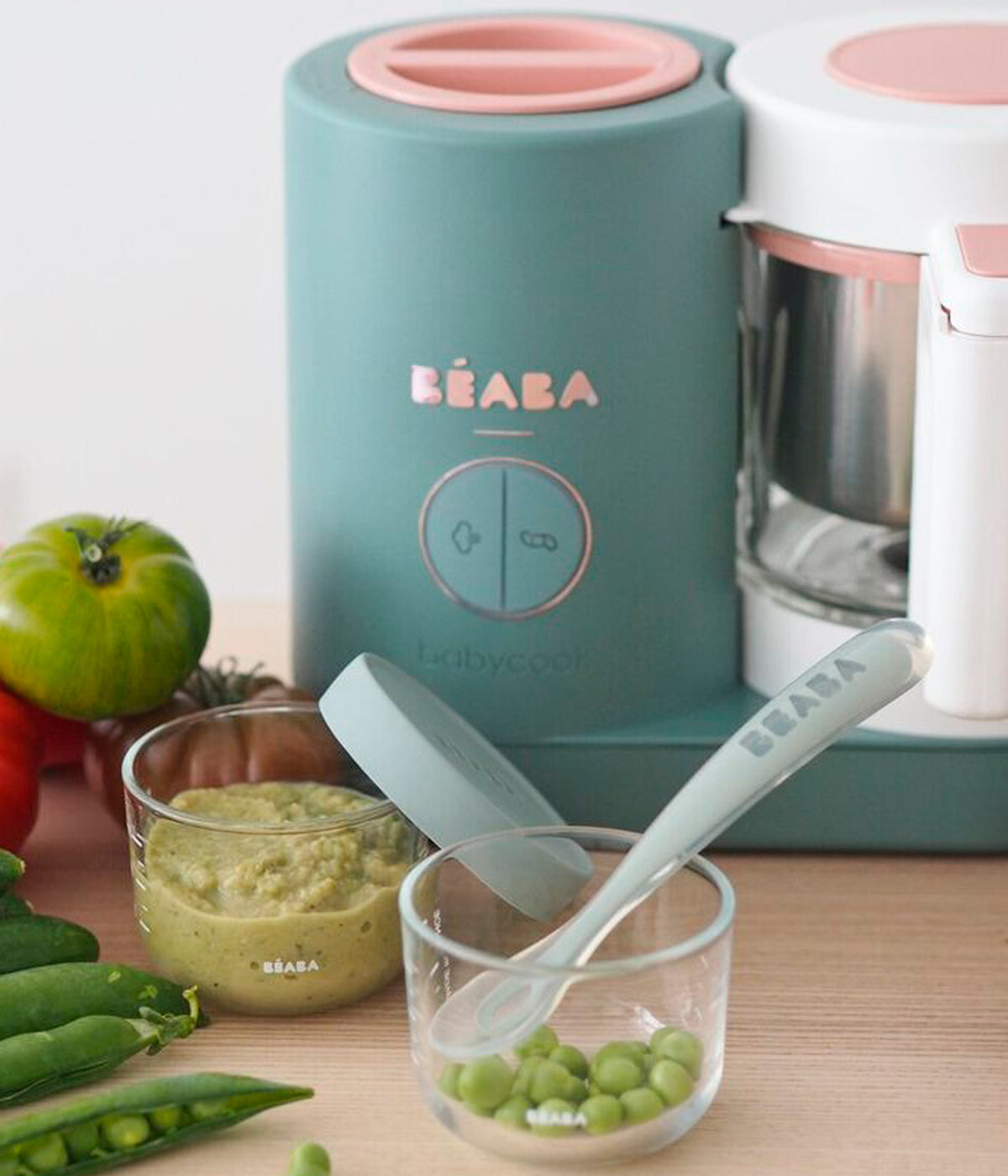 Vista frontal do Robô de Cozinha Babycook Néo da Béaba na cor Eucalyptus (verde) com recipientes com comida preparada pelo mesmo.