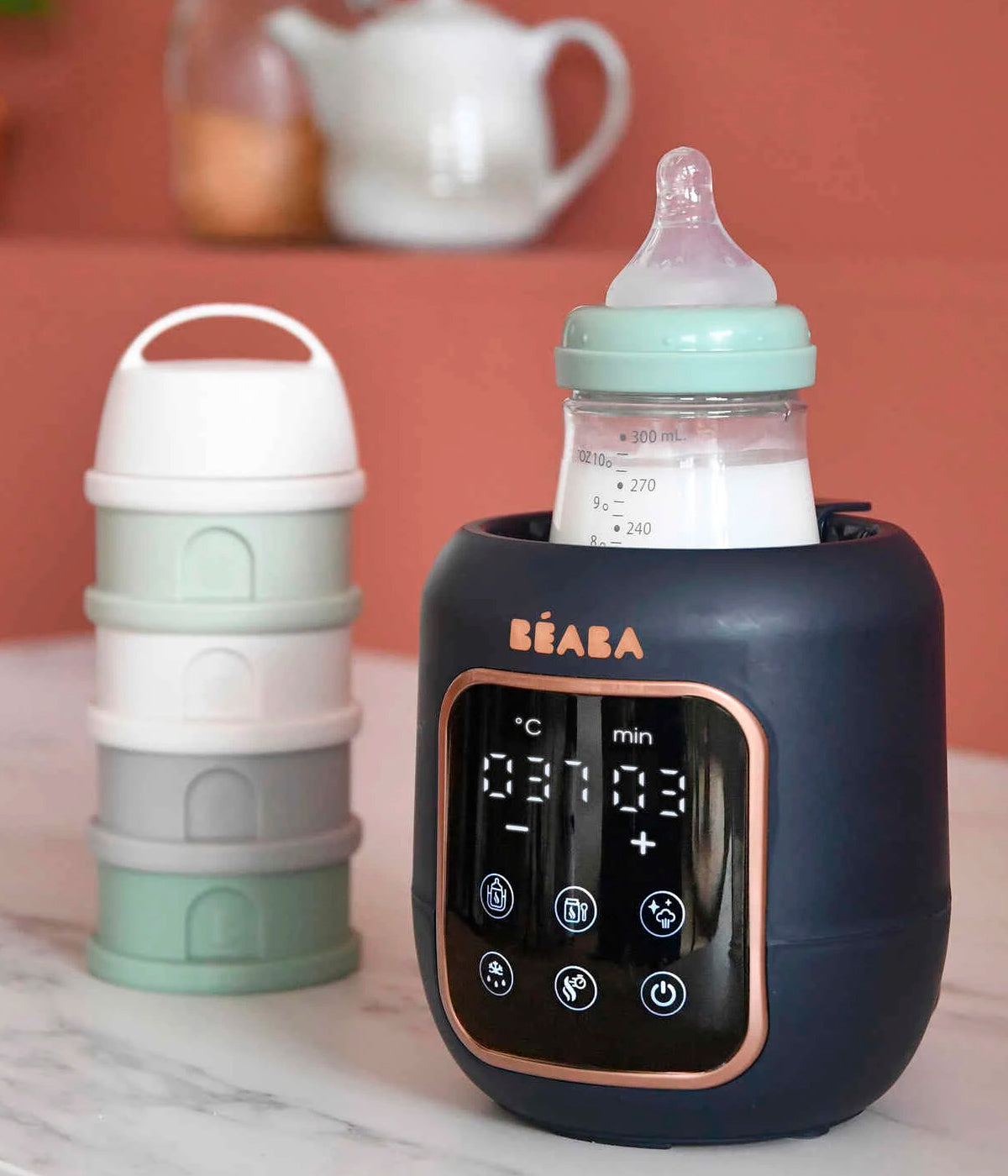 Vista frontal do aquecedor de biberões Multi Milk da Béaba na cor Night Blue (azul índigo) com biberão inserido.