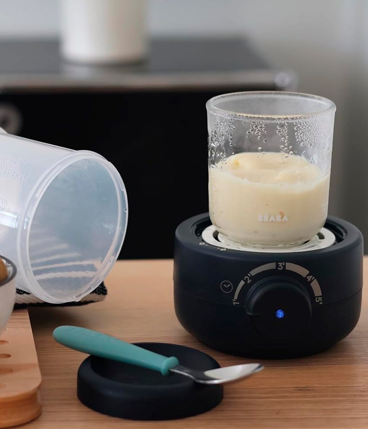 Aquecedor de biberões Babymilk Second da Béaba na cor Night Blue (azul índigo) a aquecer boião de papa para o bebé.