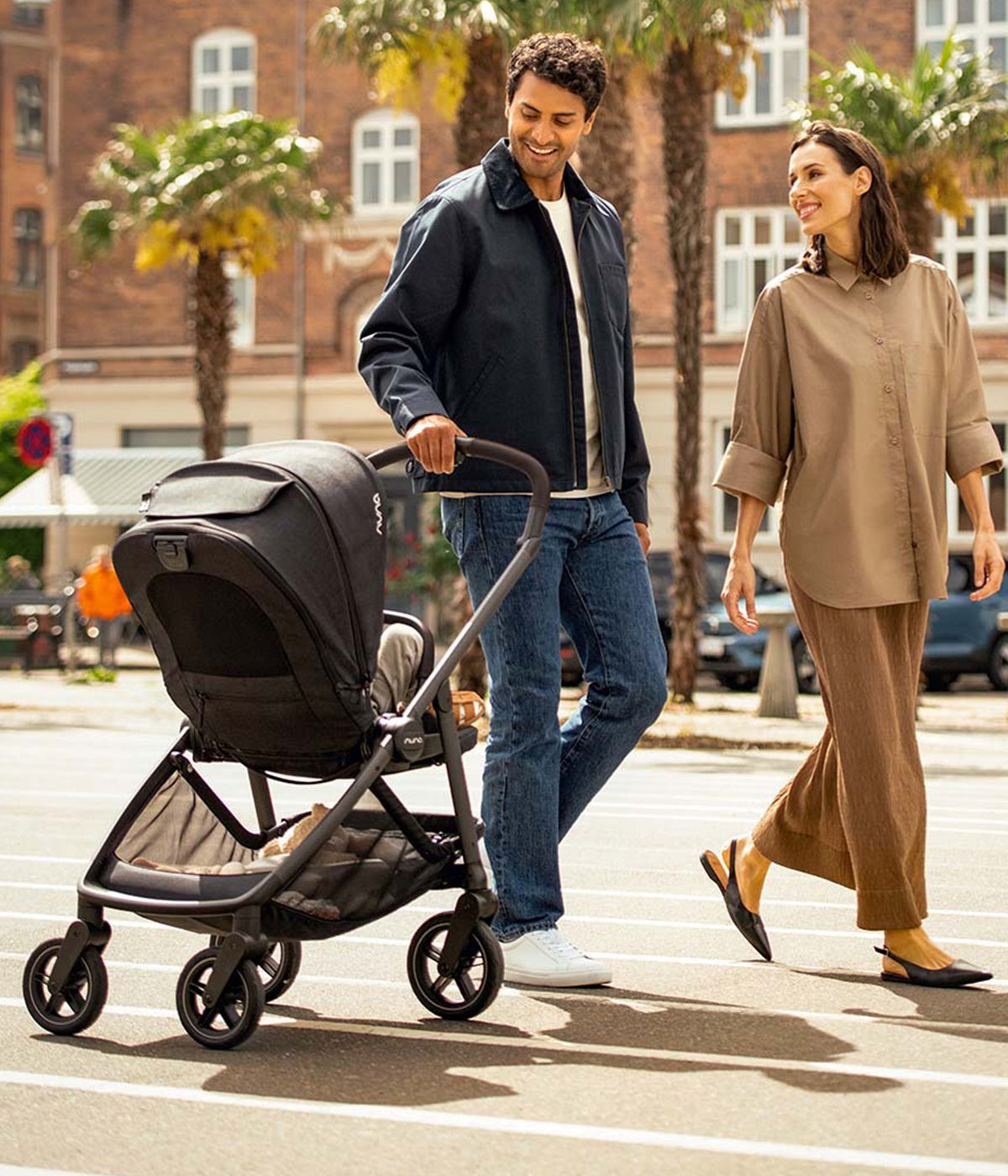 Pais a utilizar o carrinho de passeio Swiv da marca Nuna na cor Pistachio. Elegante carrinho concebido para proporcionar uma experiência de passeio inovadora, graças às suas exclusivas rodas com rotação 360°, acionadas através de um simples botão na pega.