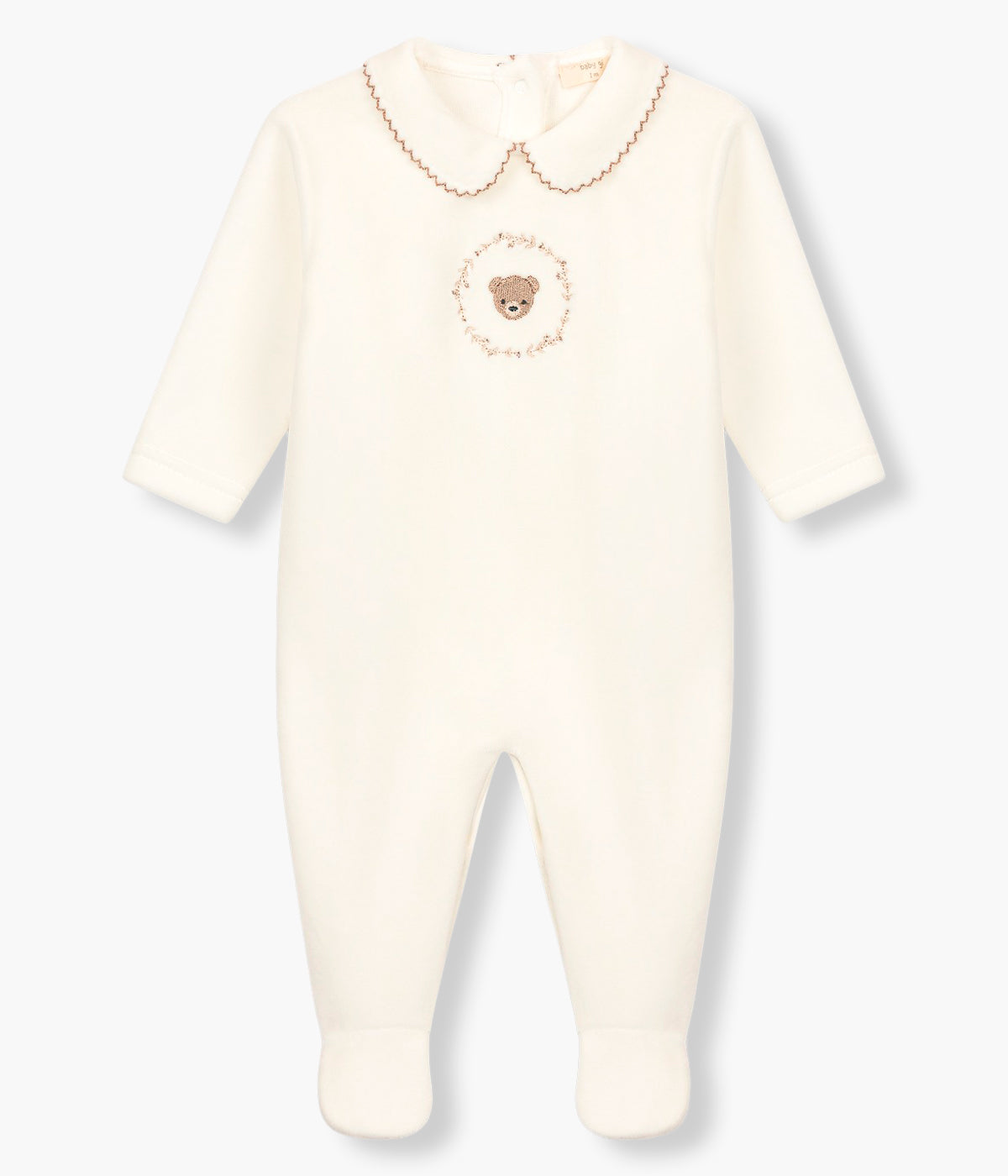 Vista frontal do babygrow em veludo pérola da Baby Gi para bebé e recém-nascido(a). Gola redonda cortada com picueta castanha. Fofo focinho de urso com coroa de ramos bordado no peito. Abertura com molas de pressão nas costas e entrepernas.