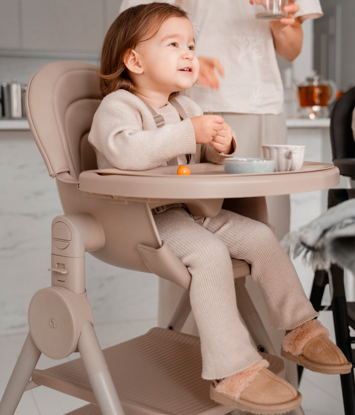 Vista com bebé a utilizar a cadeira evolutiva para bebé 3 em 1 Ozy da marca Anex na cor Fluff. A Anex Ozy é uma cadeira concebida para acompanhar a criança desde o nascimento até aproximadamente aos 5 anos.